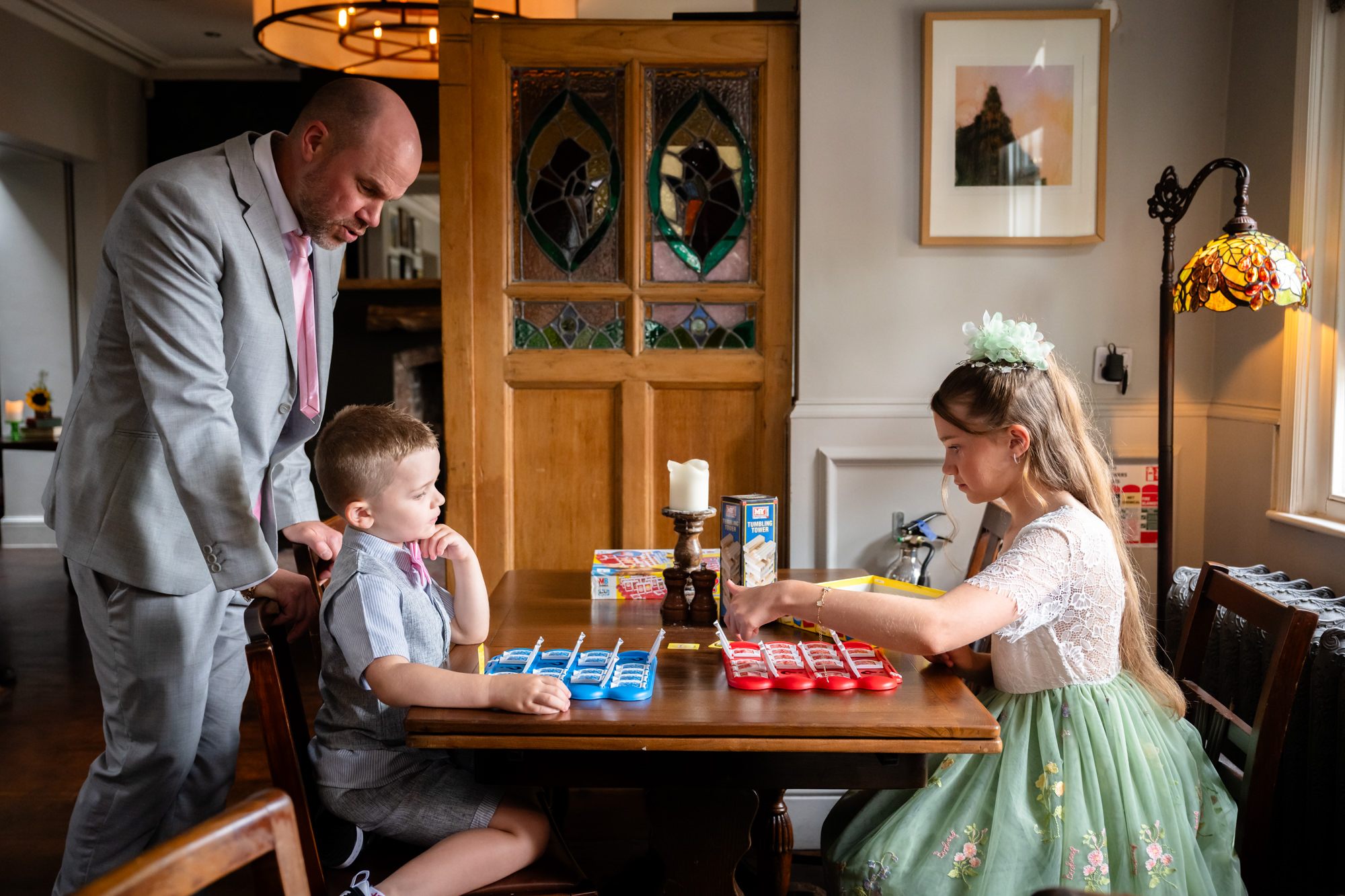 Two children playing Guess Who together at the wedding reception