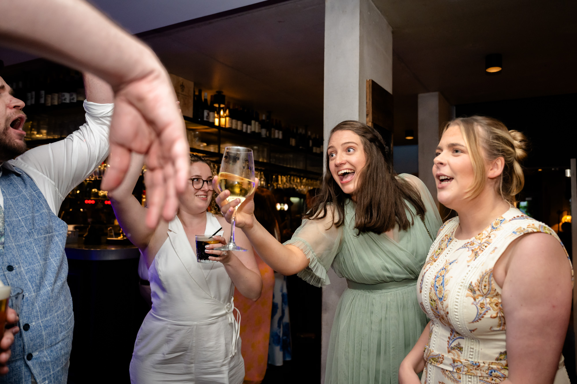 Wedding guests laughing and cheering together with drinks raised
