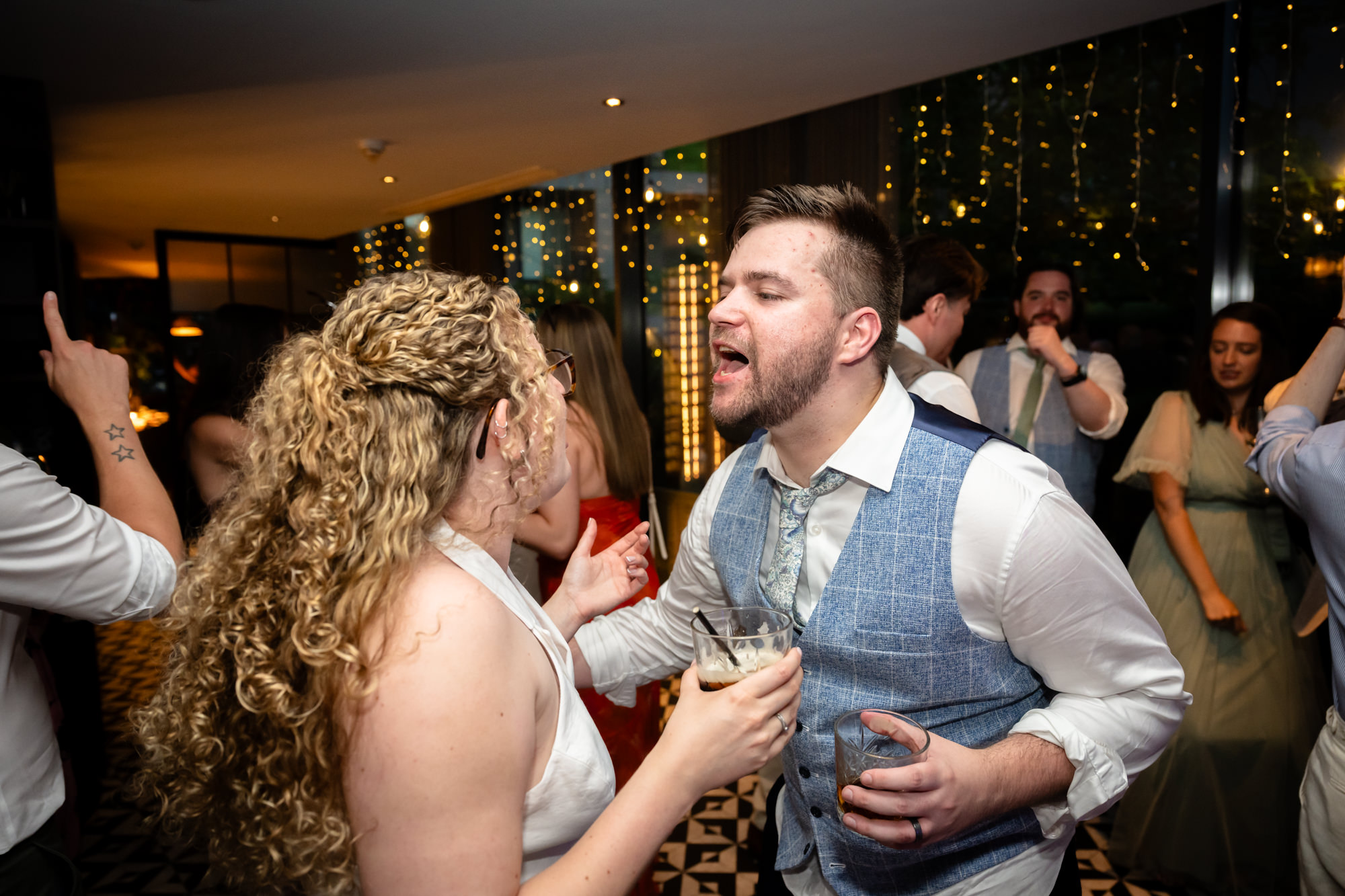 Bride and groom dancing together, groom singing along
