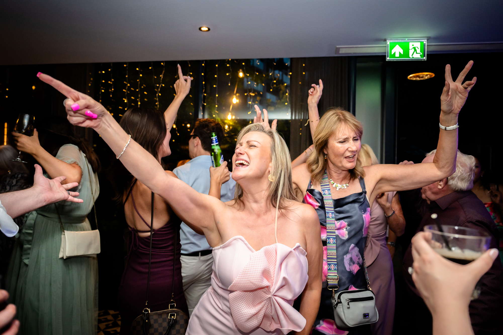 Wedding guests dancing with arms raised, celebrating together